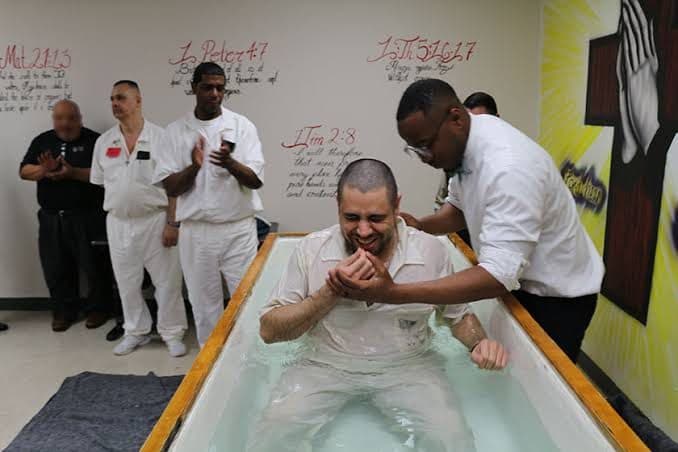 A man being baptized while others look on